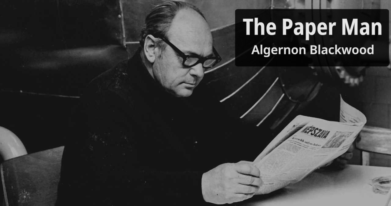 A bespectacled man reads his newspaper.